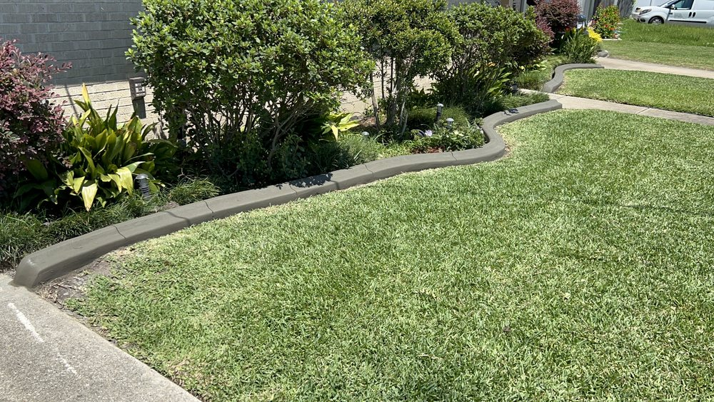 Trimmed hedges and a cared-for lawn bordered by a curved planting bed